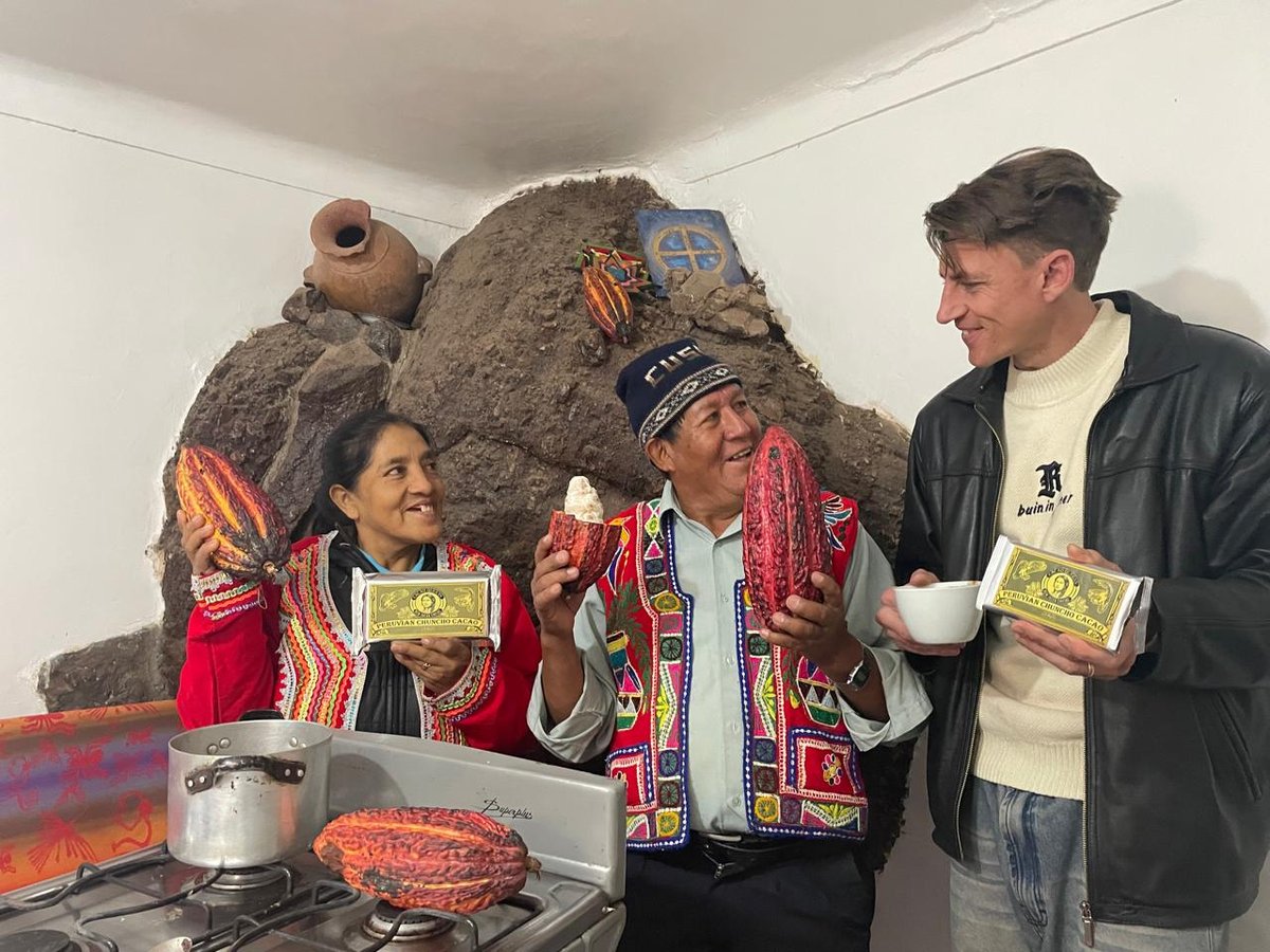 Austin in the kitchen in Cusco with his parents-in-law, holding cacao pods and a bar