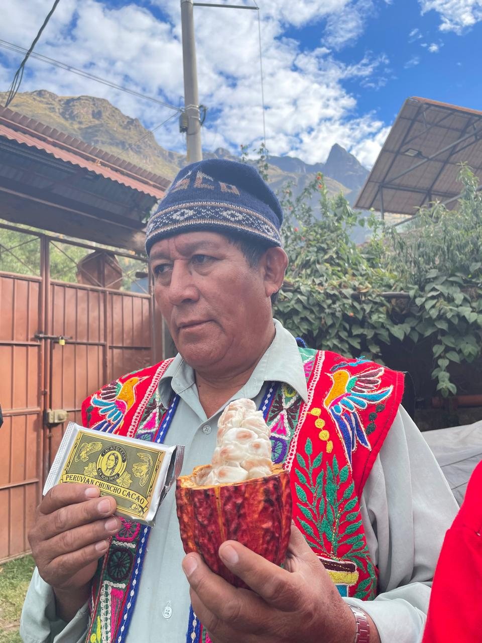 Austin's father-in-law in traditional Andean dress, holding an open cacao pod